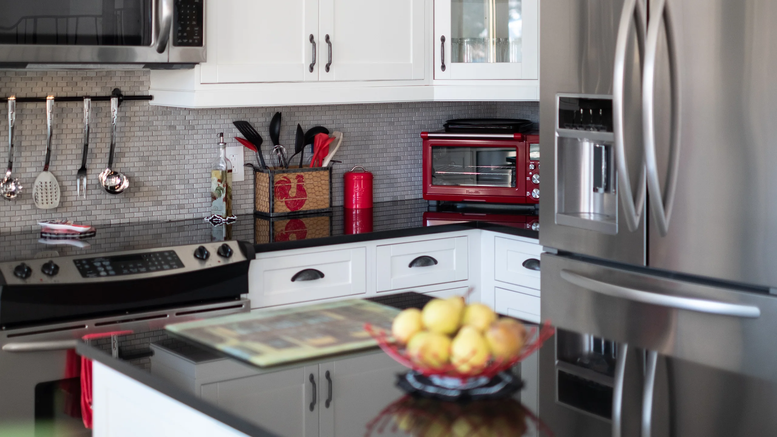 White Shaker-style kitchen with dark countertops and stainless steel appliances