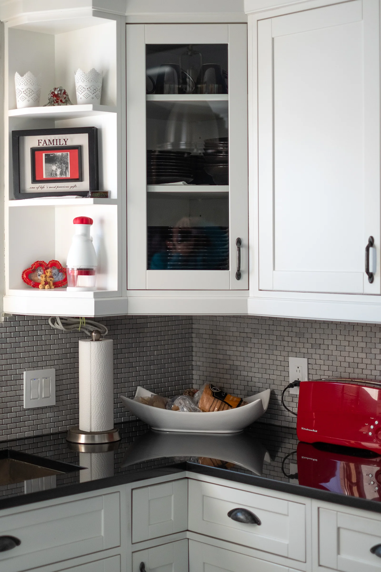 Kitchen corner with open shelving and dark countertop contrast