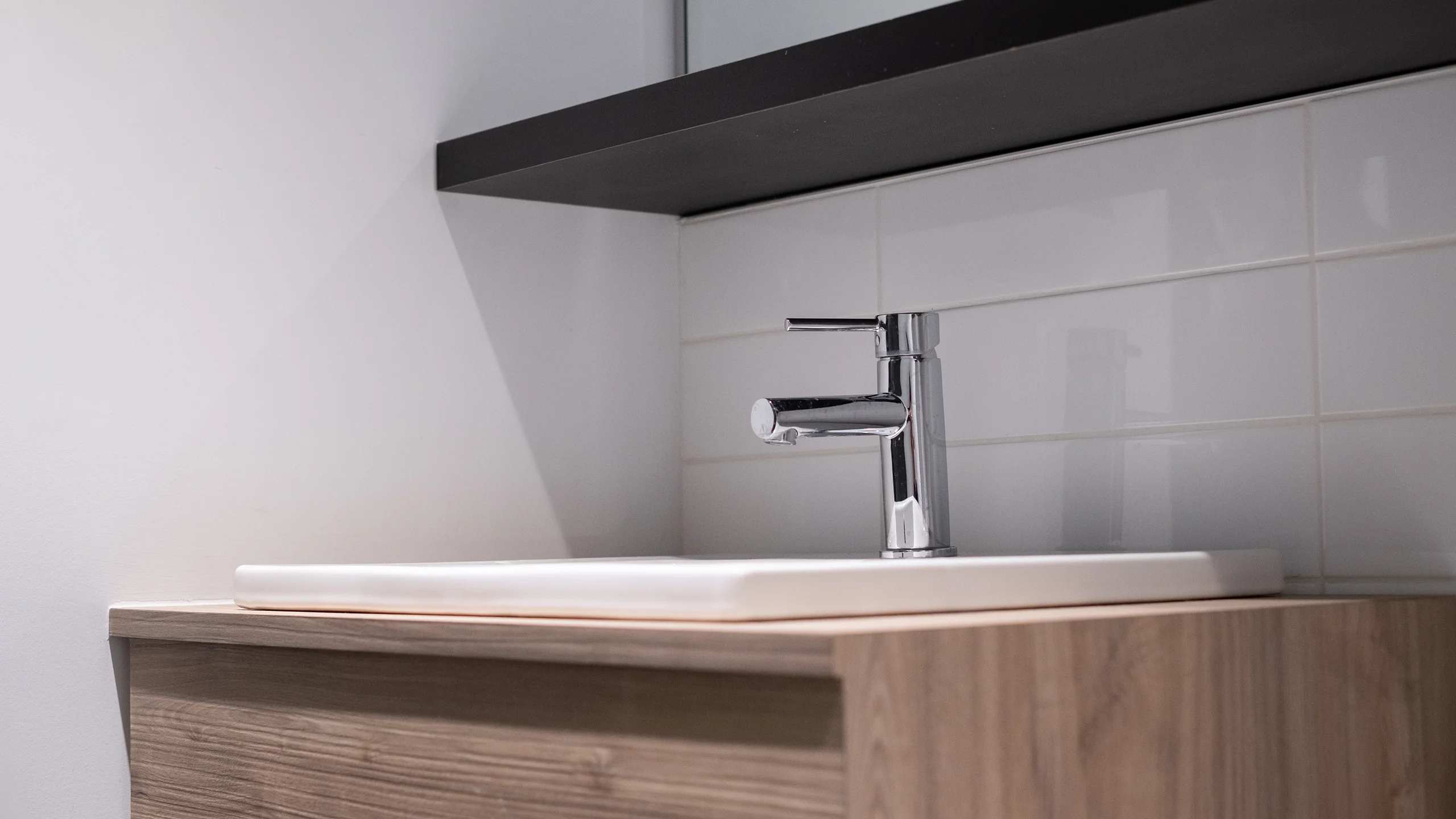 Custom wood-grain vanity with white basin and chrome fixtures
