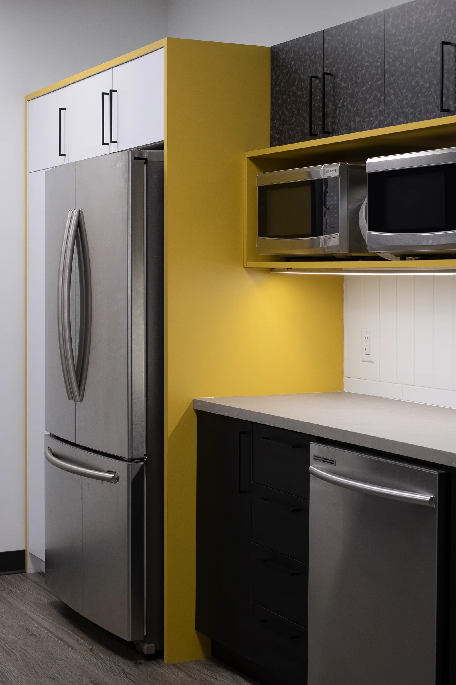 Corner kitchen view with mustard yellow accent panels and custom microwave integration