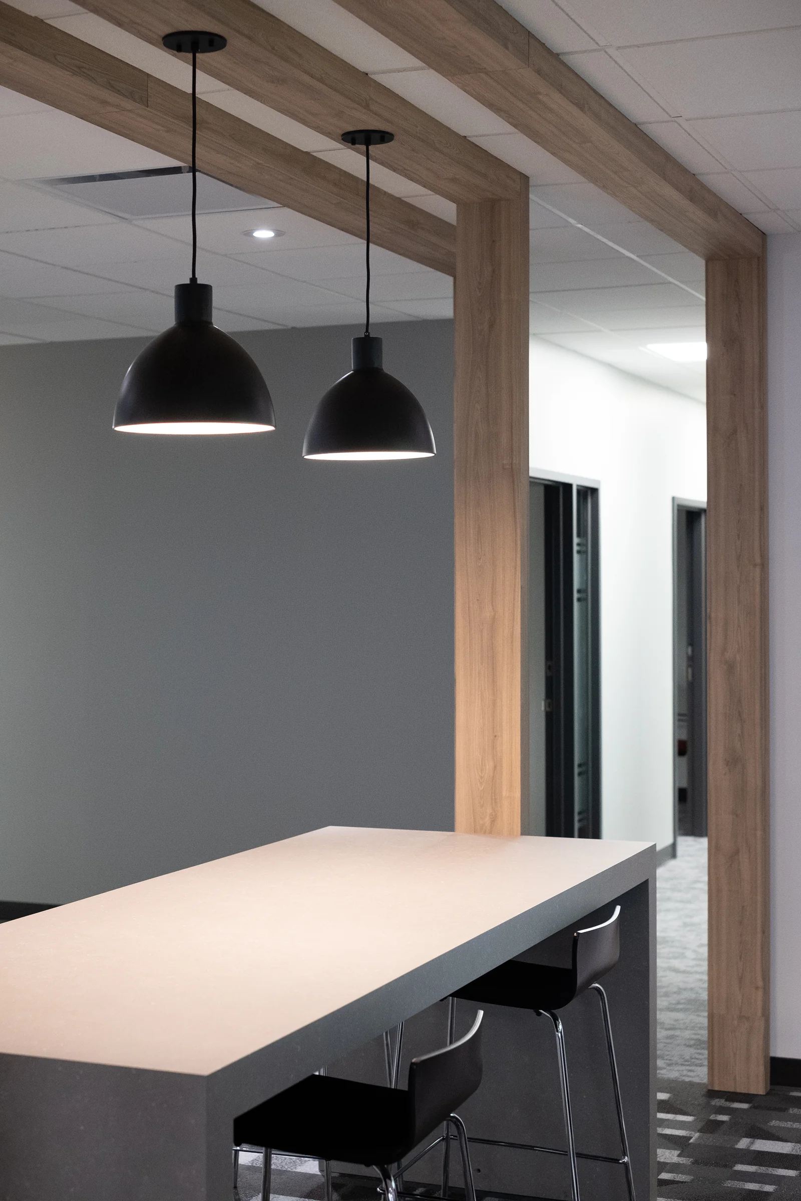 Communal counter with bar stool seating and wood-beam ceiling