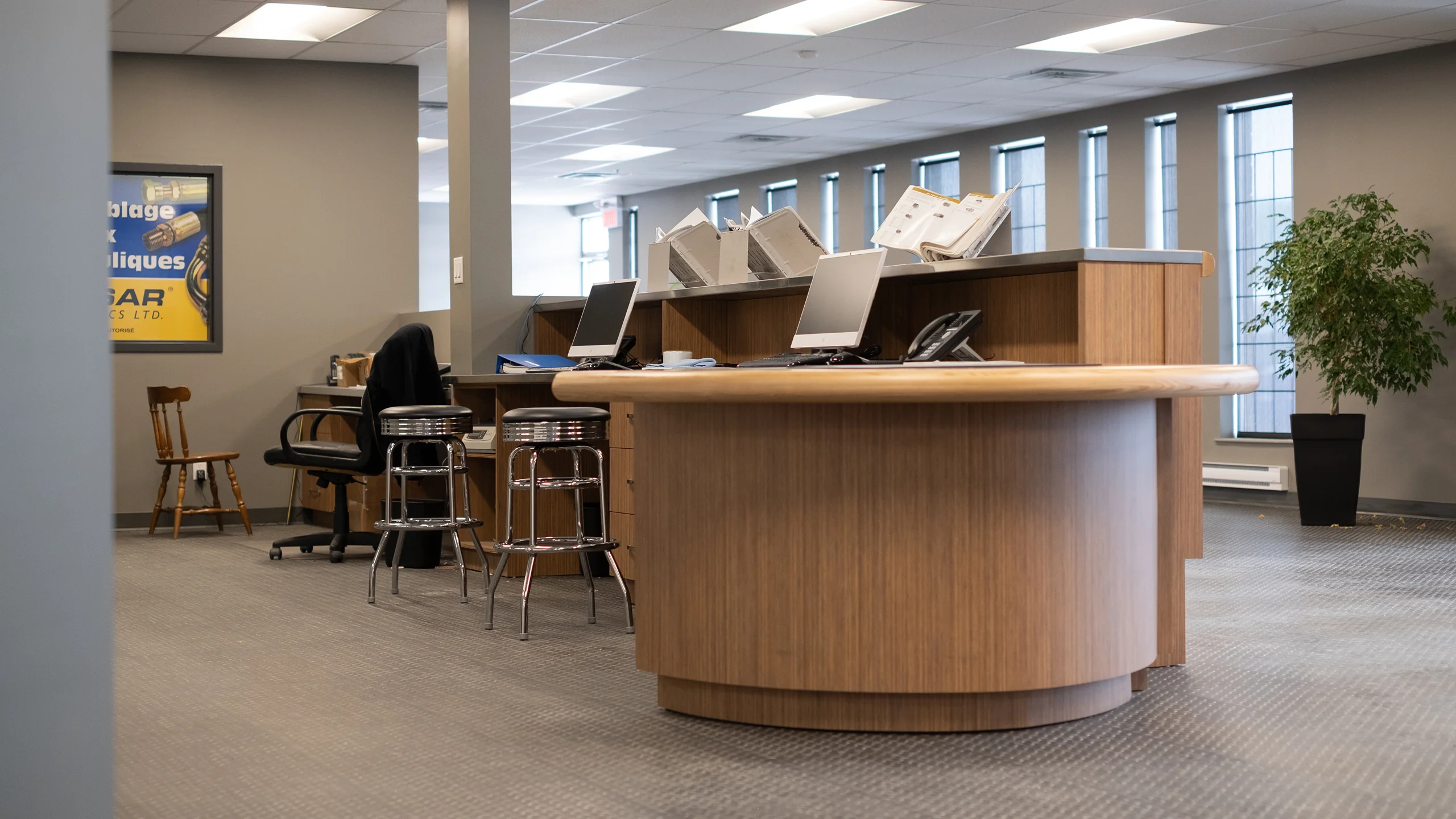 Reception area with wood-grain desk and chrome bar stools