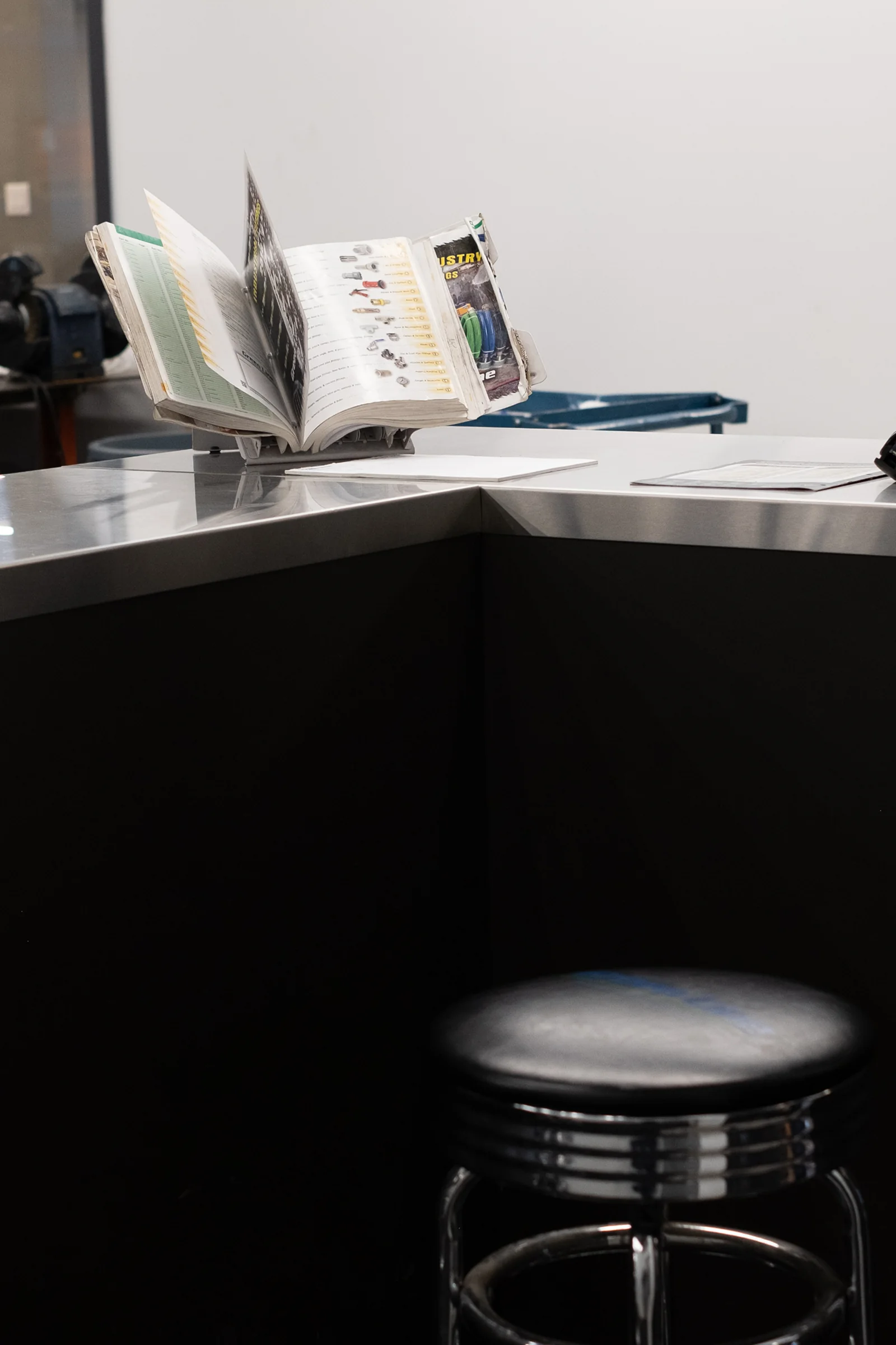 Metallic counter with industrial catalogue and chrome stool