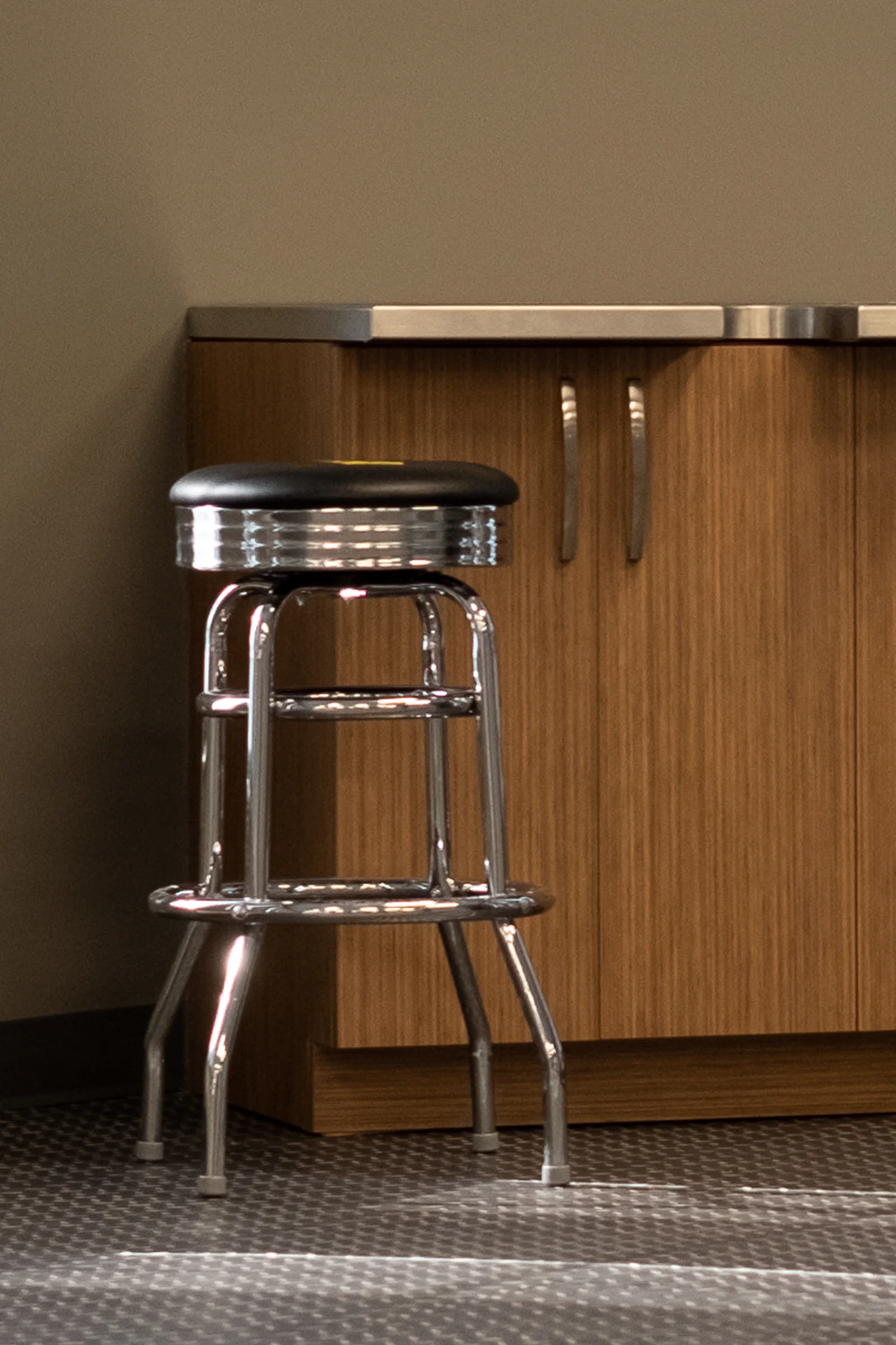 Chrome stool and wood cabinet with metallic counter