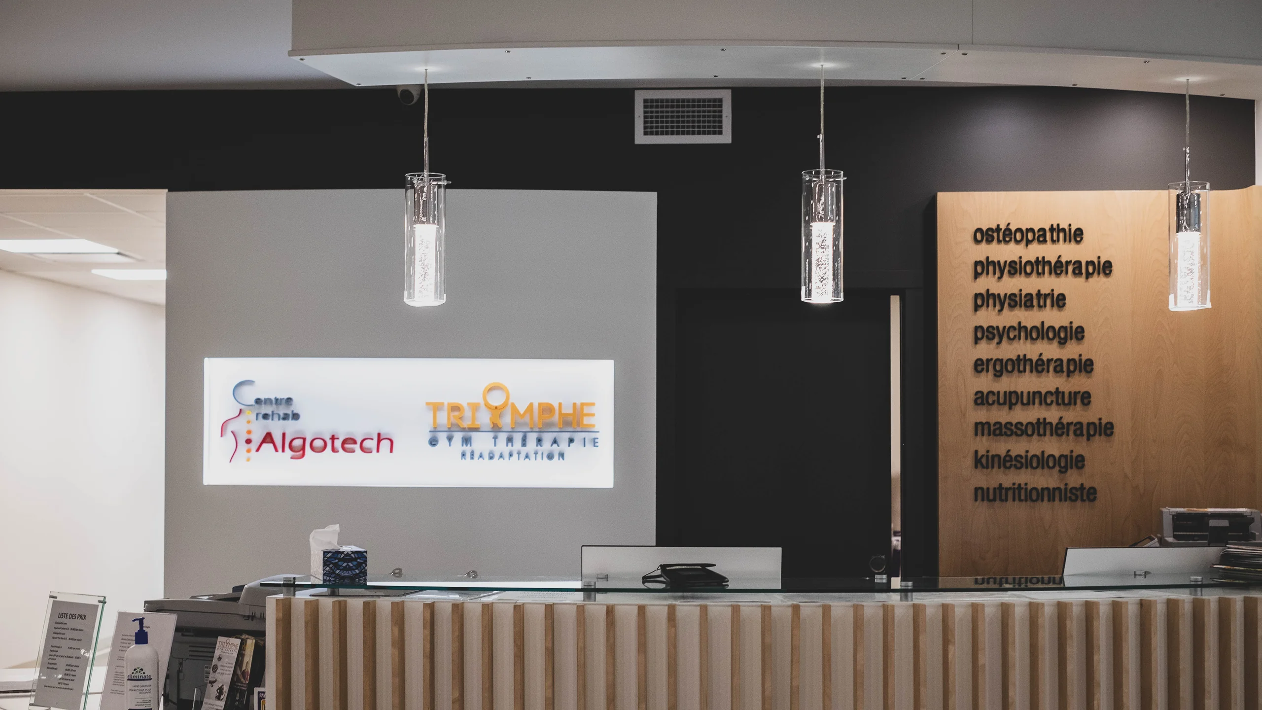 Reception area with ribbed wood desk and Centre Algotech branding