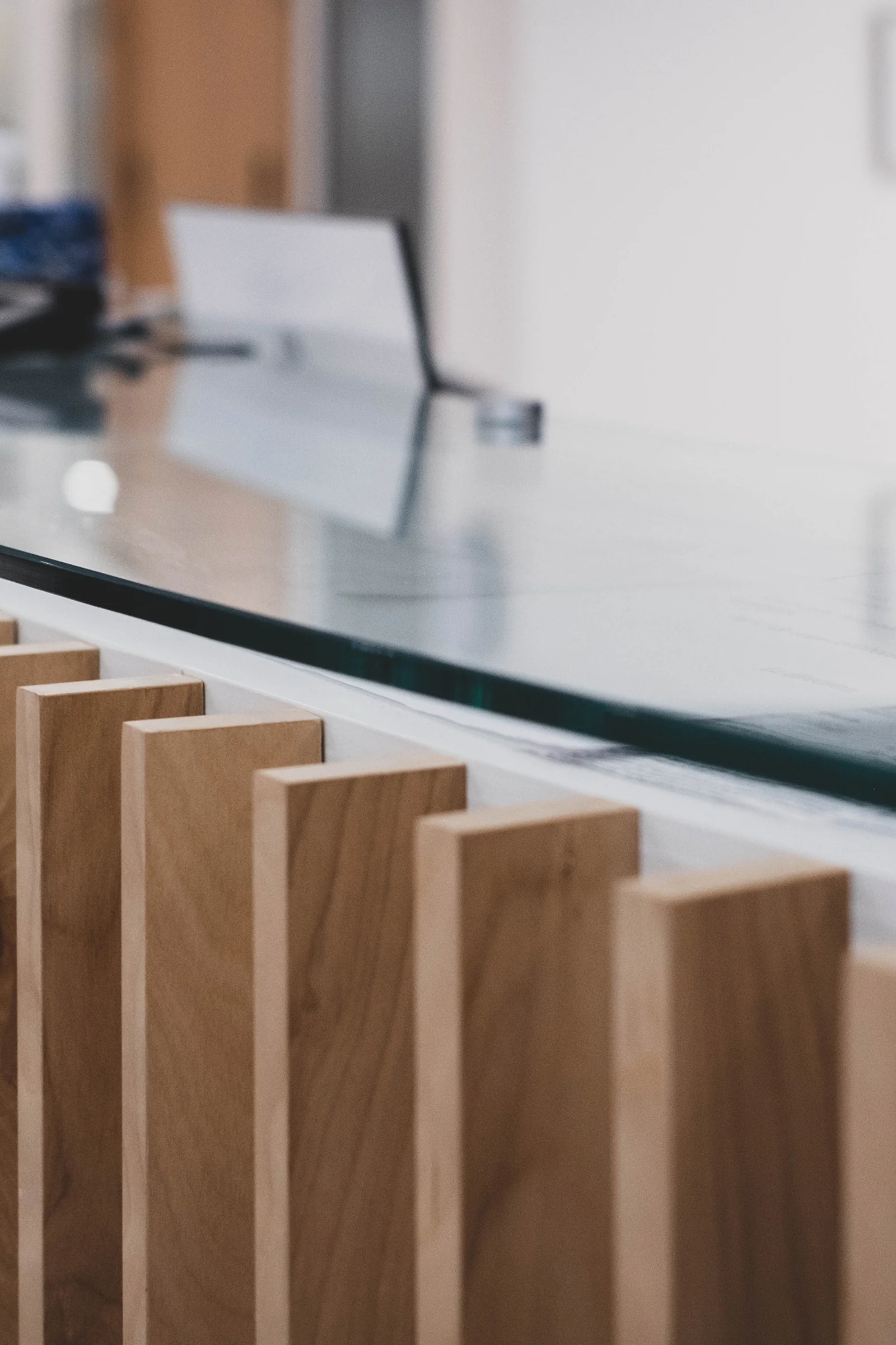 Detail of vertical wood slats and glass countertop