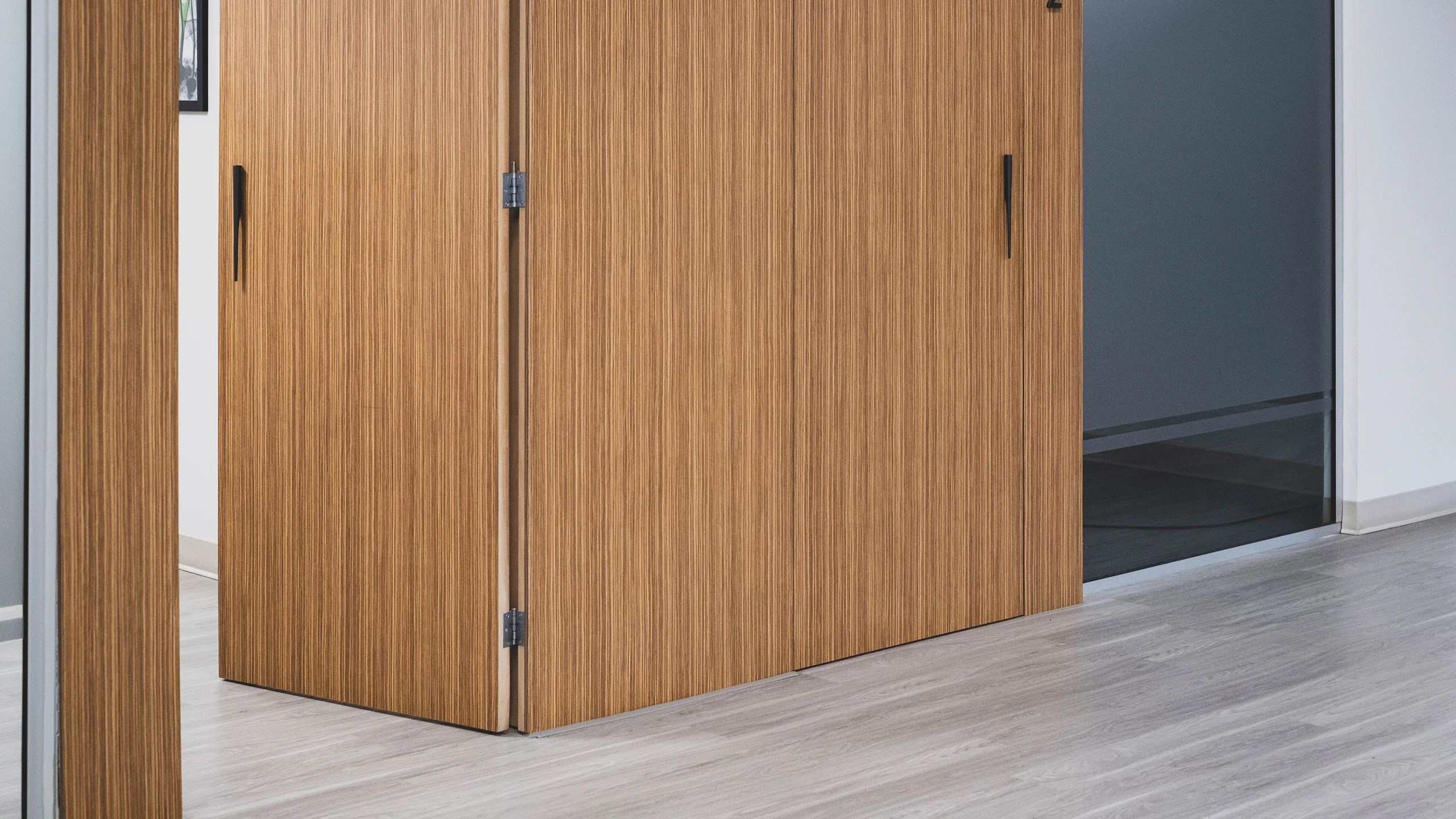 Wood-paneled doors with vertical grain and minimal hardware