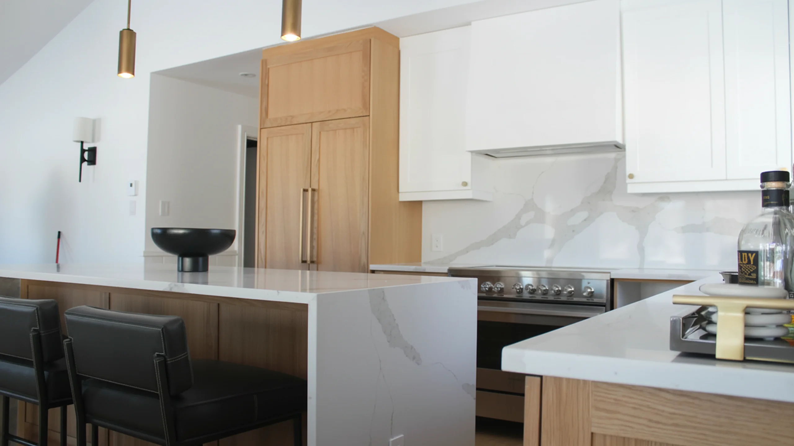 Kitchen island with marble waterfall edge and wood cabinetry