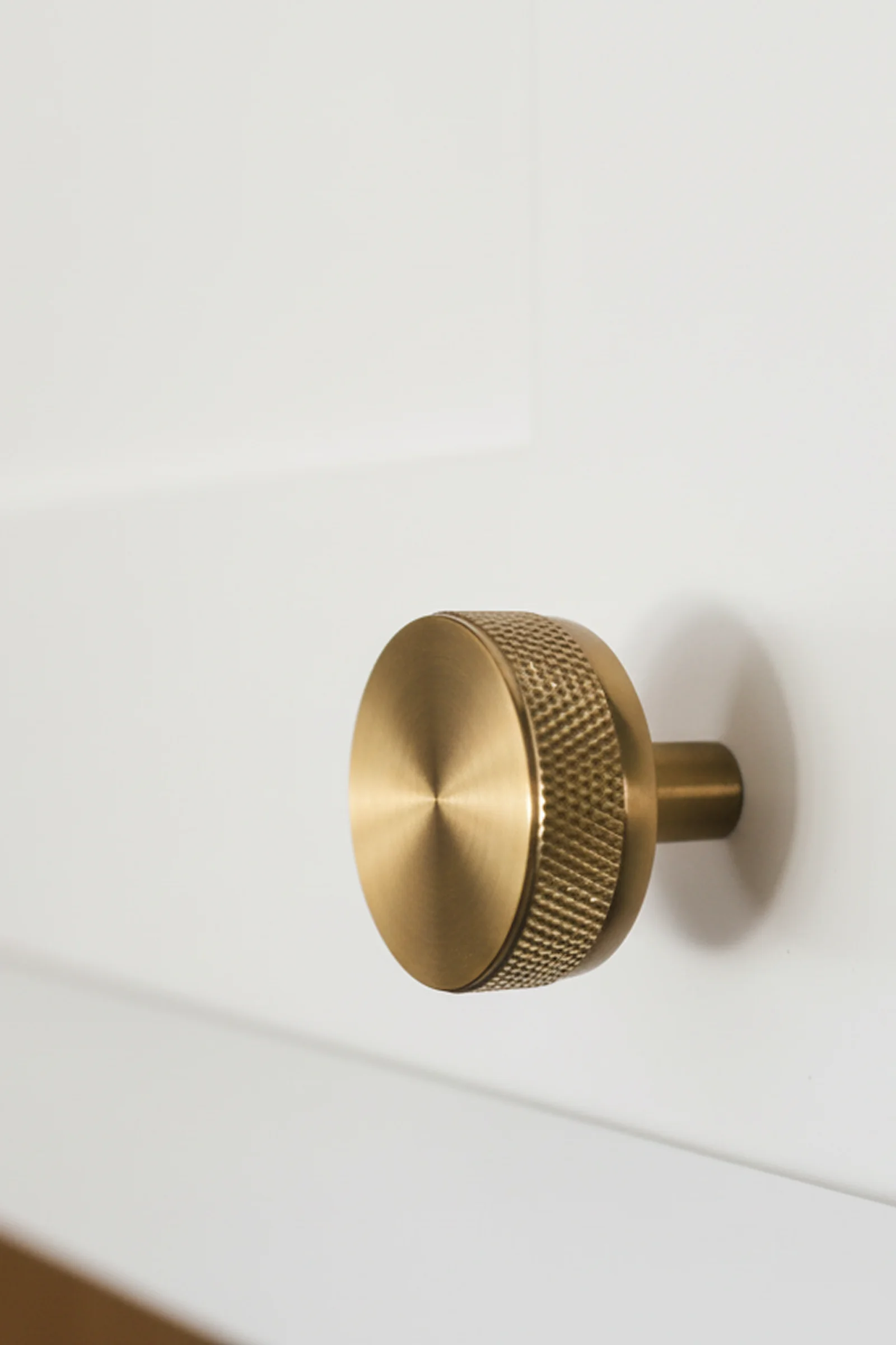 Brass cabinet knob on Shaker-style white cabinetry